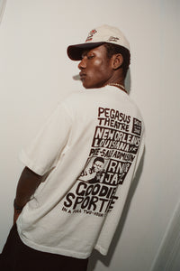 Person wearing a white t-shirt with text and graphics, standing against a plain background