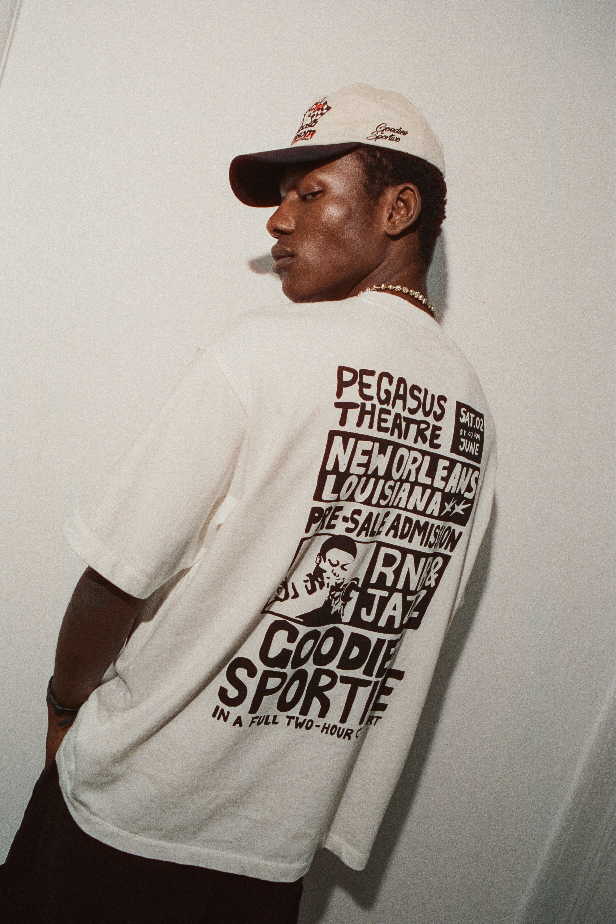 Person wearing a white t-shirt with text and graphics, standing against a plain background