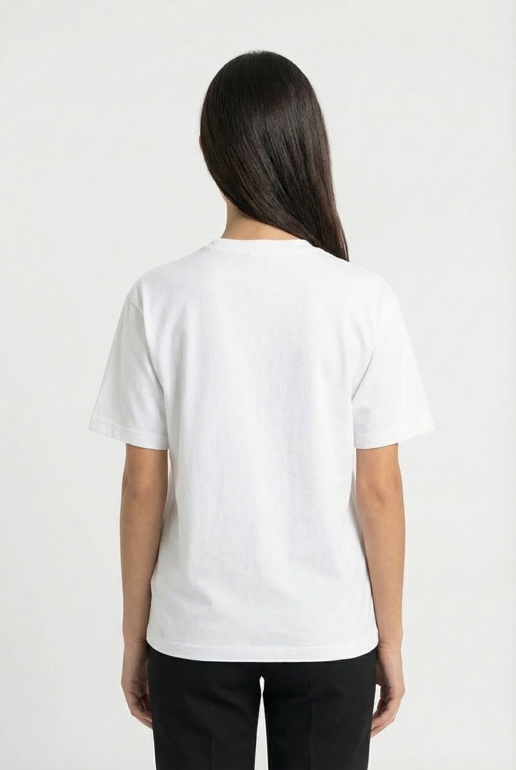 Person wearing a plain white t-shirt on a white background