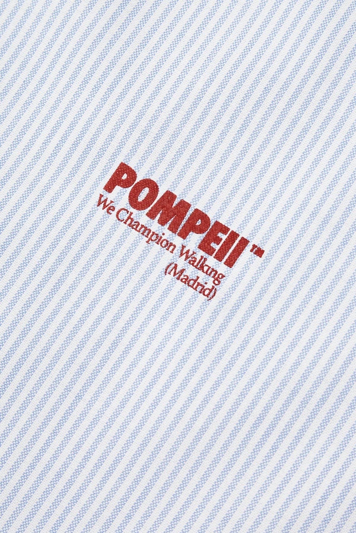 Text 'POMPEII We Champion Walking (Madrid)' on a light blue striped background
